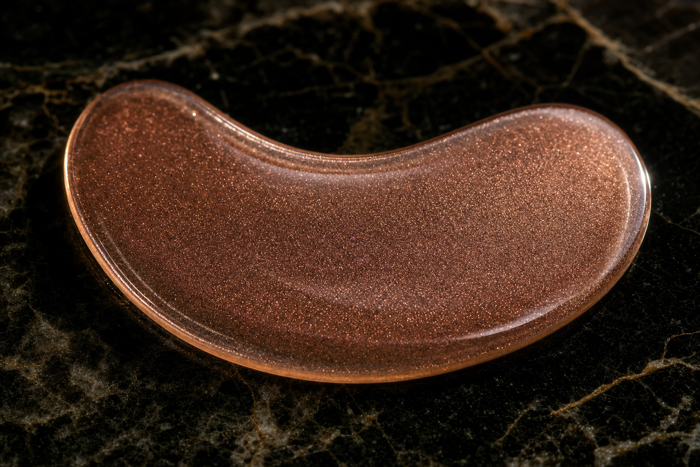 Close-up of Lumis Rose Gold Eye Patches, a beauty accessory by Lumis Beauty, showing the shiny, rose gold-colored patches for under-eye care.